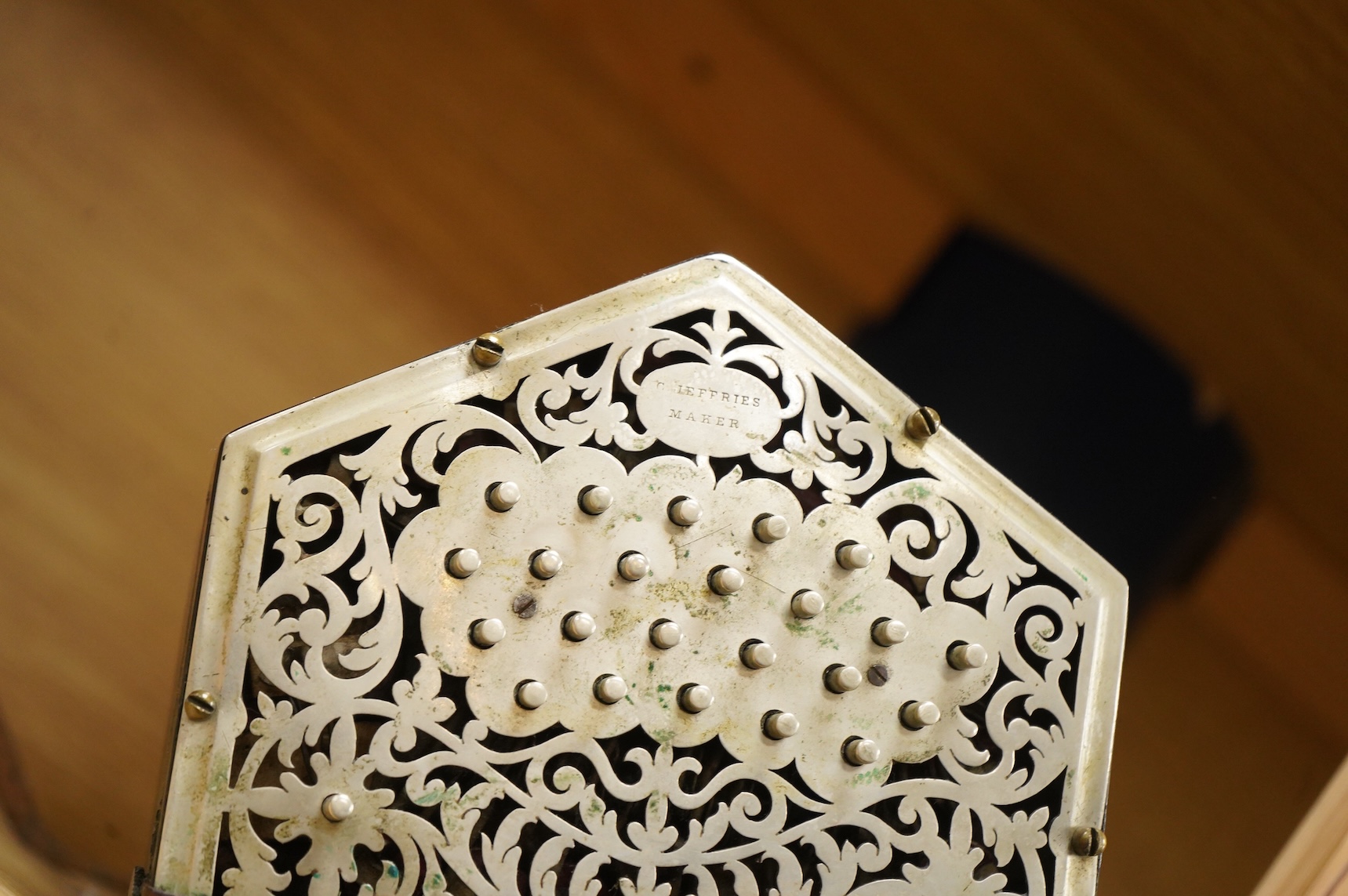 A Jeffries hexagonal concertina with pierced silvered metal ends, and gilt tooled leather bellows, maker’s mark stamped to the metal work on one end